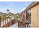 Cozy balcony view with wood table and chairs overlooking the neighborhood and sunny sky at 90 Cedar Dunes Dr, New Smyrna Beach, FL 32169