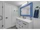 Stylish bathroom with a blue-framed mirror, vanity with storage, and wainscoting for added charm at 90 Cedar Dunes Dr, New Smyrna Beach, FL 32169
