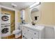 Bathroom with white vanity, oval mirror, and stackable washer/dryer at 90 Cedar Dunes Dr, New Smyrna Beach, FL 32169