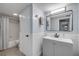Well-lit bathroom with gray vanity, wainscoting, and a shower/tub combination, offering a refreshing space at 90 Cedar Dunes Dr, New Smyrna Beach, FL 32169