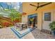 Welcoming patio area featuring stone flooring, a dining set, sliding glass door, and tropical plants at 90 Cedar Dunes Dr, New Smyrna Beach, FL 32169
