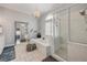 Luxurious bathroom with a soaking tub, glass shower, and decorative mirror; a spa-like experience at 90 Cunningham Dr, New Smyrna Beach, FL 32168