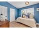 Blue bedroom featuring daybed, a window, and decorative accents, creating a cozy and inviting space at 90 Cunningham Dr, New Smyrna Beach, FL 32168
