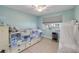 Light and airy bedroom with blue walls, a bed with built-in drawers, and natural light from the window at 90 Cunningham Dr, New Smyrna Beach, FL 32168