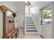 Welcoming entryway with staircase, wooden bench, and decor, leading to a view of the outdoor pool area at 90 Cunningham Dr, New Smyrna Beach, FL 32168