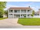 Charming two-story home with a large front yard and a spacious two-level balcony at 90 Cunningham Dr, New Smyrna Beach, FL 32168