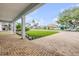 Inviting front yard featuring a brick driveway, manicured lawn, and a covered porch with stately columns at 90 Cunningham Dr, New Smyrna Beach, FL 32168