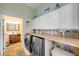 Well-appointed laundry room with ample cabinets and modern front-loading washer/dryer at 90 Cunningham Dr, New Smyrna Beach, FL 32168