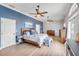 Relaxing primary bedroom with blue accent wall, multiple ceiling fans, and wood-look flooring at 90 Cunningham Dr, New Smyrna Beach, FL 32168