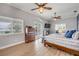 Bright main bedroom featuring wood floors, ceiling fans, balcony access, and an ensuite living room at 90 Cunningham Dr, New Smyrna Beach, FL 32168