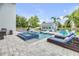 Backyard pool and spa with pavers, lounge chairs, lush landscaping, and detached guest house at 90 Cunningham Dr, New Smyrna Beach, FL 32168
