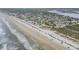 Expansive aerial view showcases beautiful beachfront, ocean, and surrounding community at 951 N Atlantic Ave, New Smyrna Beach, FL 32169
