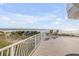 Ocean view from balcony with chairs, wooden deck and white metal railing at 951 N Atlantic Ave, New Smyrna Beach, FL 32169
