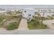 Aerial view of the beachfront home with lush landscaping, a driveway, and panoramic ocean views at 951 N Atlantic Ave, New Smyrna Beach, FL 32169
