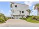 The home's eye-catching architectural details, landscaped front yard, and private driveway are on display at 951 N Atlantic Ave, New Smyrna Beach, FL 32169