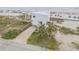 Aerial view of the beachfront home with lush landscaping, a driveway, and panoramic ocean views at 951 N Atlantic Ave, New Smyrna Beach, FL 32169