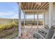 Inviting covered patio with stone flooring, seating, and views of the beach at 951 N Atlantic Ave, New Smyrna Beach, FL 32169
