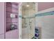 Shower with glass enclosure and shelving, and an accent tile border at 951 N Atlantic Ave, New Smyrna Beach, FL 32169