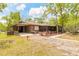 Charming brown home with a covered porch and well-maintained landscaping at 98 Cypress Pond Rd, Port Orange, FL 32128