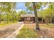 Cozy brown home surrounded by mature trees with a front porch at 98 Cypress Pond Rd, Port Orange, FL 32128