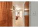 Hallway with light carpet leads to a bedroom with floral bedding, with a bathroom visible at the end at 98 Cypress Pond Rd, Port Orange, FL 32128