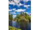 Scenic view of a lake surrounded by trees, with a blue sky and scattered clouds above at 98 Cypress Pond Rd, Port Orange, FL 32128