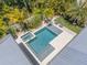 Aerial view of a rectangular pool surrounded by lush landscaping and seating at 102 Inlet Shores Dr, New Smyrna Beach, FL 32168