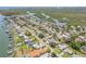 An aerial view features a home with a pool, surrounded by lush landscaping in a waterfront community at 102 Inlet Shores Dr, New Smyrna Beach, FL 32168