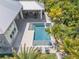 Aerial view of a private pool with mature tropical landscaping at 102 Inlet Shores Dr, New Smyrna Beach, FL 32168