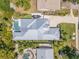 An aerial view shows a modern home with a pool, spa, lush landscaping, and a gray metal roof at 102 Inlet Shores Dr, New Smyrna Beach, FL 32168