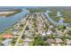 An aerial view features a home with a pool, surrounded by lush landscaping in a waterfront community at 102 Inlet Shores Dr, New Smyrna Beach, FL 32168