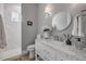 Updated bathroom featuring a walk-in shower, vanity, and a large round mirror at 102 Inlet Shores Dr, New Smyrna Beach, FL 32168