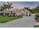 Beautiful exterior of a modern home with a well-manicured lawn, palm trees, and a concrete driveway at 102 Inlet Shores Dr, New Smyrna Beach, FL 32168