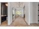 Elegant hallway with herringbone wood floors, a large mirror, and views into the living spaces at 102 Inlet Shores Dr, New Smyrna Beach, FL 32168