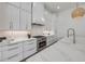 Bright kitchen featuring marble countertops, stainless steel appliances and a stylish range hood at 102 Inlet Shores Dr, New Smyrna Beach, FL 32168