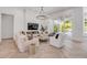 Elegant living room with fireplace, herringbone floors, and sliding glass doors to pool area at 102 Inlet Shores Dr, New Smyrna Beach, FL 32168