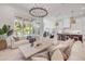 Bright living room featuring a large chandelier, herringbone floors, and access to a pool area at 102 Inlet Shores Dr, New Smyrna Beach, FL 32168