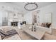 Open-concept living room flowing into kitchen with grand chandelier and herringbone flooring at 102 Inlet Shores Dr, New Smyrna Beach, FL 32168