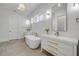 Modern main bathroom with dual sink vanities, a soaking tub, and elegant lighting at 102 Inlet Shores Dr, New Smyrna Beach, FL 32168