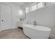 Modern main bathroom with a luxurious tub, vanity, and elegant lighting fixtures at 102 Inlet Shores Dr, New Smyrna Beach, FL 32168