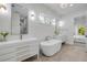 Elegant main bathroom with dual sinks, a luxurious tub, and natural lighting at 102 Inlet Shores Dr, New Smyrna Beach, FL 32168