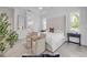 Bright main bedroom featuring two chairs, a luxurious bed, and access to the main bathroom at 102 Inlet Shores Dr, New Smyrna Beach, FL 32168