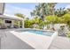 A luxurious backyard features a pool with a spa, an outdoor kitchen, lush landscaping and a patio with lounge seating at 102 Inlet Shores Dr, New Smyrna Beach, FL 32168