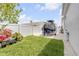 A well-maintained yard features a boat on a trailer, white vinyl fencing, and lush landscaping at 102 Inlet Shores Dr, New Smyrna Beach, FL 32168