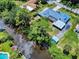 This is an aerial view of a neighborhood home next to a river surrounded by lush trees at 108 Dee St, New Smyrna Beach, FL 32168
