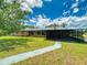 A single-story home with a screened in patio area and luscious green yard at 108 Dee St, New Smyrna Beach, FL 32168