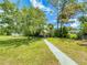 Beautiful backyard with a covered sitting area, lush greenery, and a well-maintained lawn at 108 Dee St, New Smyrna Beach, FL 32168