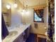 Bathroom featuring a double sink vanity with marble countertops, and a decorative window at 108 Dee St, New Smyrna Beach, FL 32168