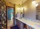 Bright bathroom featuring double sinks, a marble countertop, and a decorative mirror at 108 Dee St, New Smyrna Beach, FL 32168