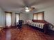 Bedroom with decorative ceiling fan, two windows, hardwood flooring, and desk area at 108 Dee St, New Smyrna Beach, FL 32168